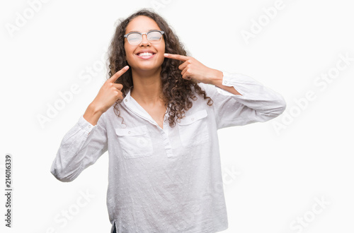 Beautiful young hispanic woman smiling confident showing and pointing with fingers teeth and mouth. Health concept.