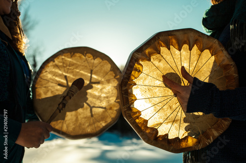 Print op canvas Women holding and playing their sacred drums outdoors in the wintertime