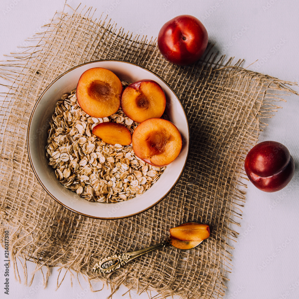 Delicious, healthy breakfast.Cereal with plum .Eco-friendly. Oatmeal porridge, breads, eggs and fruits.The idea for breakfast on white background. Natural, dietary food. Good morning. Life style Delicious, healthy breakfast.Cereal with plum .Eco-friendly. Oatmeal porridge, breads, eggs and fruits.The idea for breakfast on white background. Natural, dietary food. Good morning. Life style