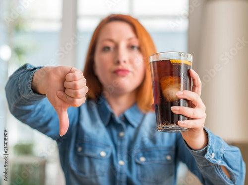 Canvas-taulu Redhead woman holding soda refreshment with angry face, negative sign showing di