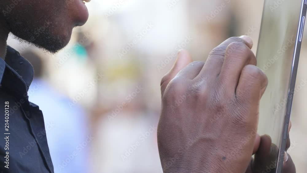 close up on young black man using digital tablet outdoor- slow motion close up on young black man using digital tablet outdoor- slow motion