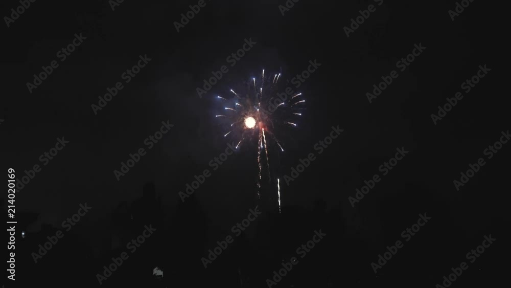Silhouette of people watching fireworks while the show is slow with not much fireworks at once Silhouette of people watching fireworks while the show is slow with not much fireworks at once
