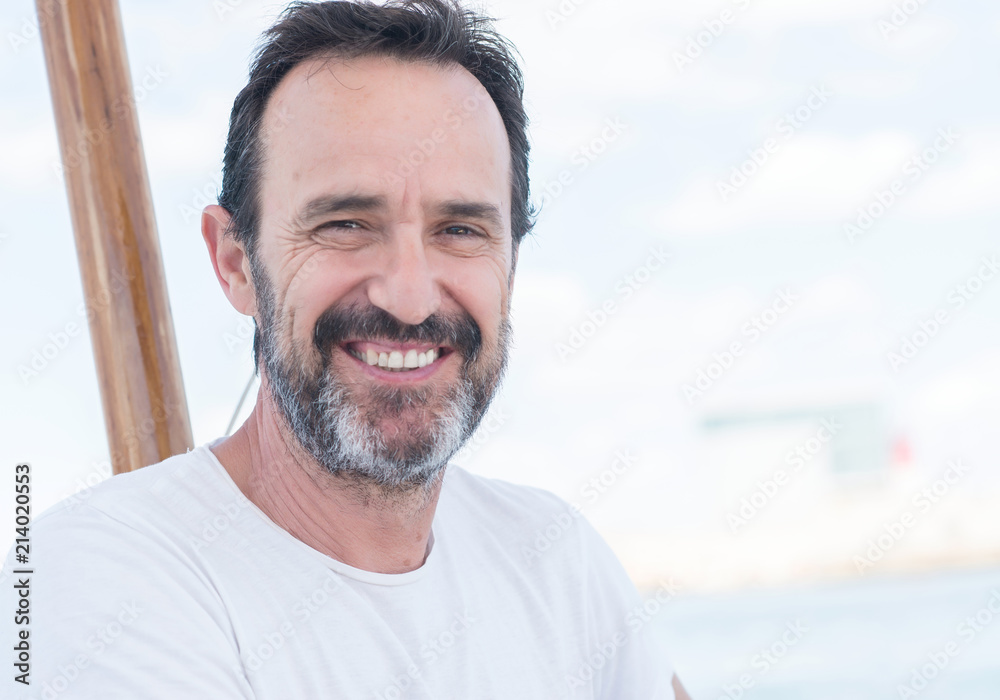 Fototapeta premium Handsome senior man traveling on sailboat and smiling happy and confident