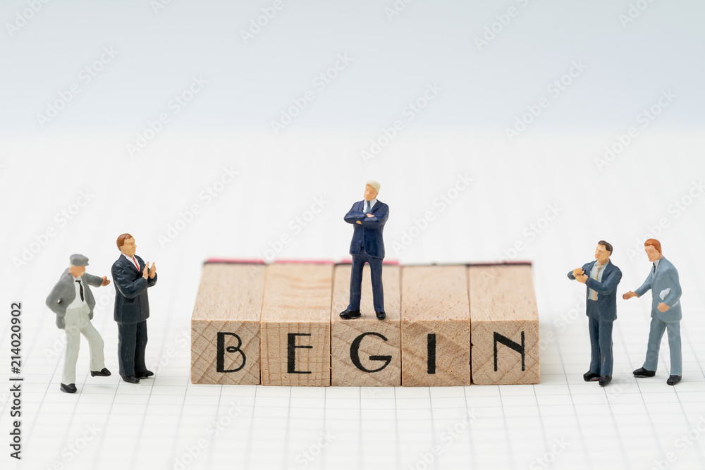 Begin, company establish or start own business concept, miniature figure businessman standing on wooden stamp building the word BEGIN on grid line note book with congratulation clapping people Begin, company establish or start own business concept, miniature figure businessman standing on wooden stamp building the word BEGIN on grid line note book with congratulation clapping people
