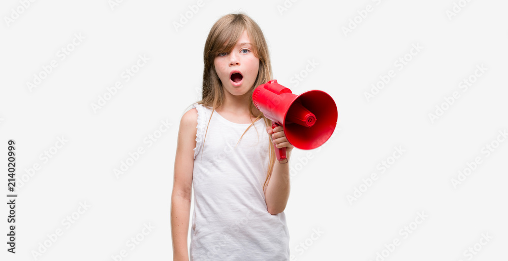 Young blonde toddler holding megaphone scared in shock with a surprise face, afraid and excited with fear expression Young blonde toddler holding megaphone scared in shock with a surprise face, afraid and excited with fear expression