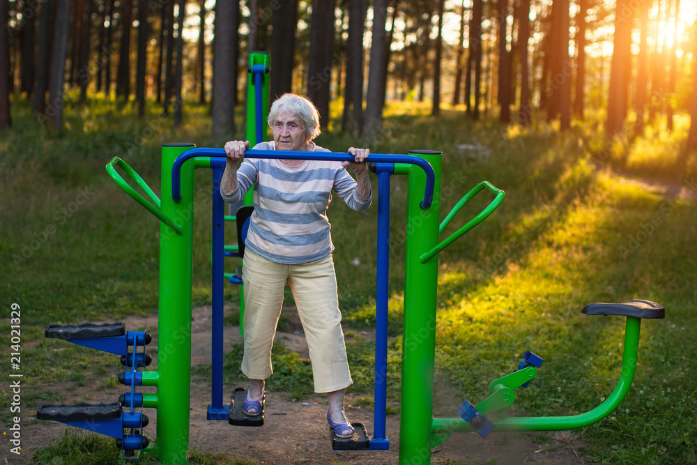 Elderly woman doing morning exercise on the street sport playground. Elderly woman doing morning exercise on the street sport playground.