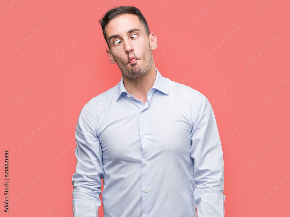 Handsome young businessman making fish face with lips, crazy and comical gesture. Funny expression. Handsome young businessman making fish face with lips, crazy and comical gesture. Funny expression.