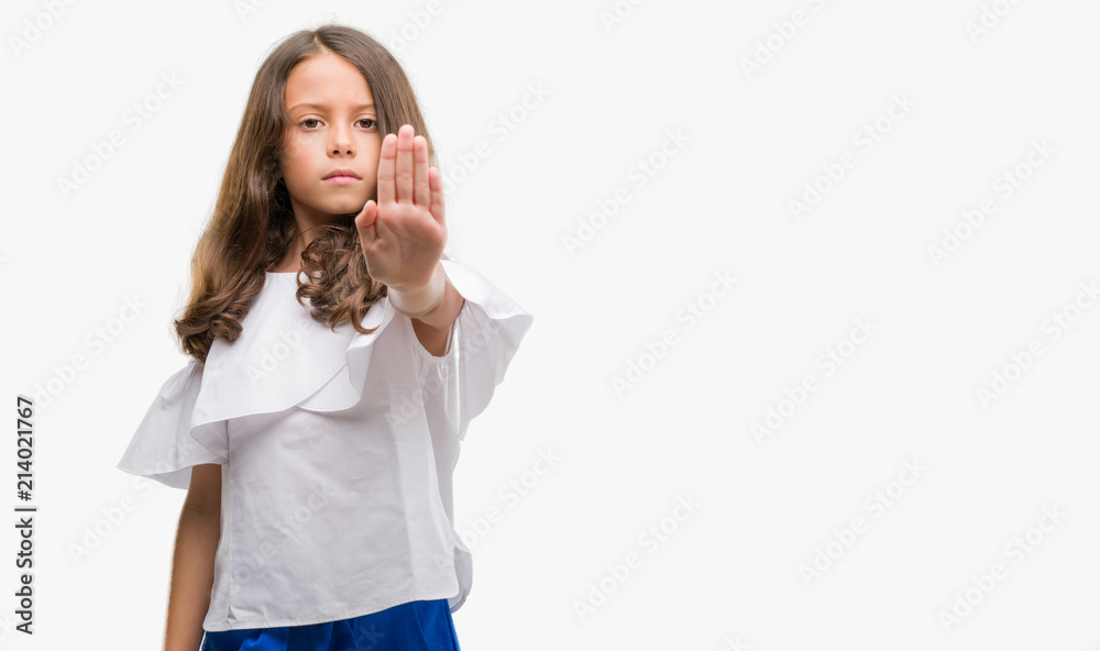 Brunette hispanic girl doing stop sing with palm of the hand. Warning expression with negative and serious gesture on the face.