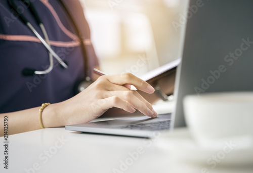 Close up short nurse hand using laptop