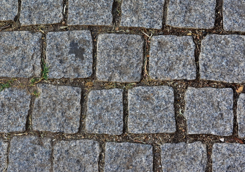 Black cobbled stone road background. Black or dark grey stone pavement texture.