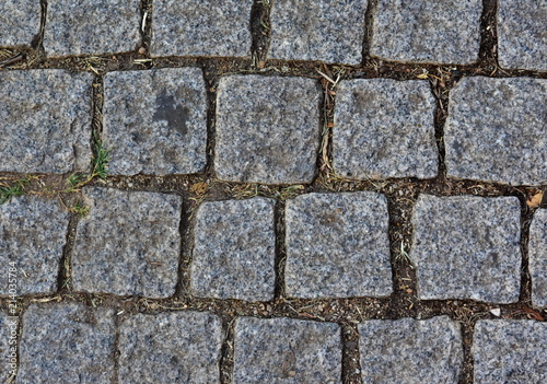 Black cobbled stone road background. Black or dark grey stone pavement texture.