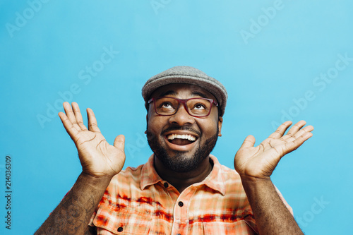 It's incredible! Portrait of a happy and excited man looking up with mouth open and both arms up photo