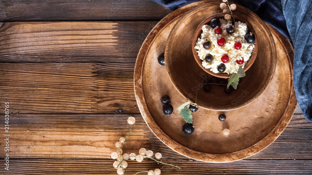 Curd dessert with berries in a clay bowl. Top view. Daylight. Space for text. Curd dessert with berries in a clay bowl. Top view. Daylight. Space for text.