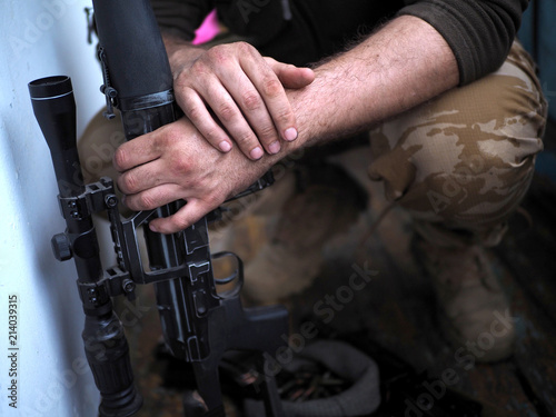 soldier hands and Sniper rifle close up. war.