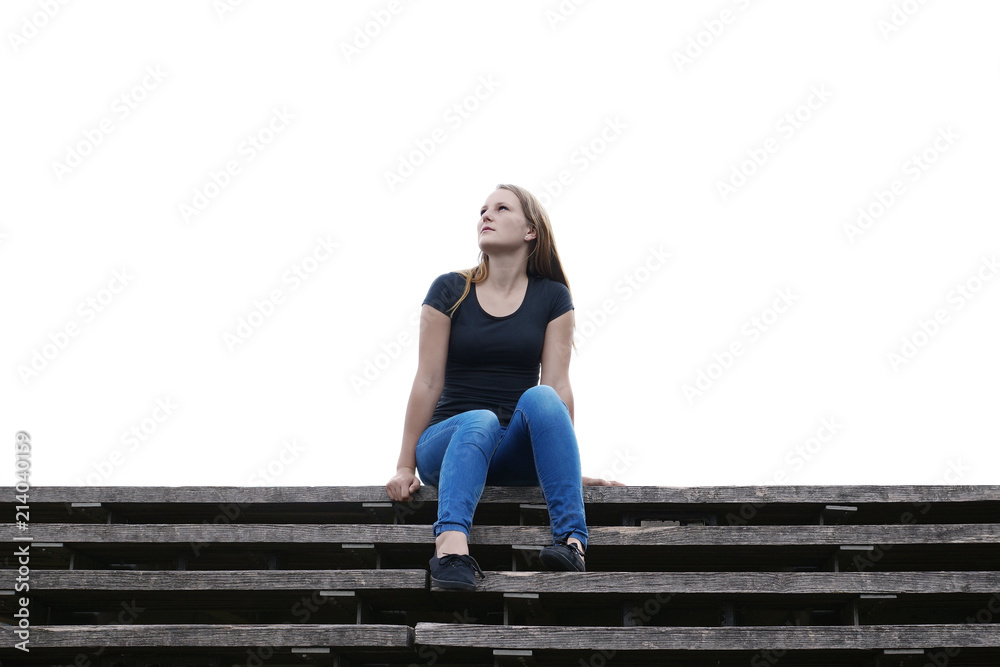 pensive young woman sitting on outside flight of stairs