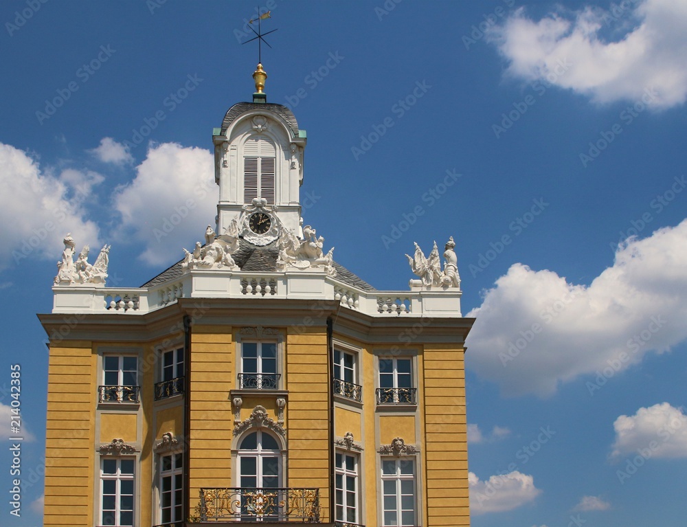 Baroque facade of Karlsruhe Residence Palace against blue sky with white clouds, Germany