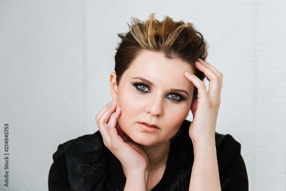 Fototapeta premium Portrait of a young woman with a short haircut with makeup smoky eyes