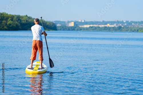 Obraz na płótnie Man paddling on a SUP board w salonie