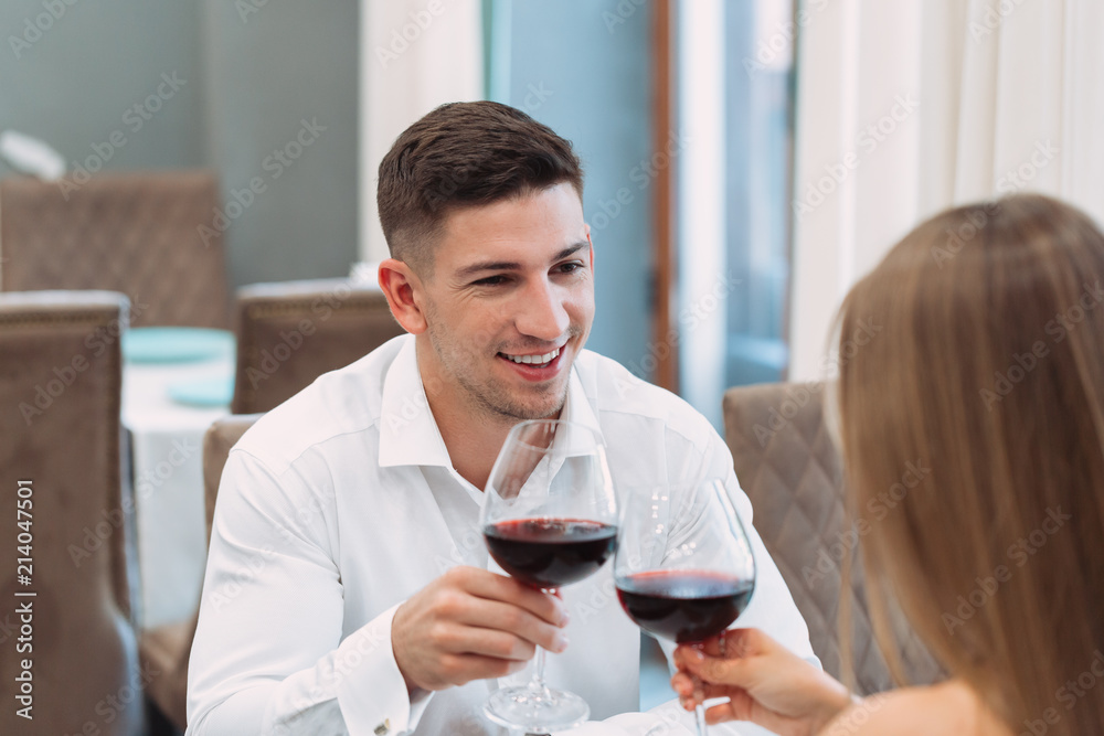 Beautiful young couple with glasses of red wine in luxury restaurant Beautiful young couple with glasses of red wine in luxury restaurant