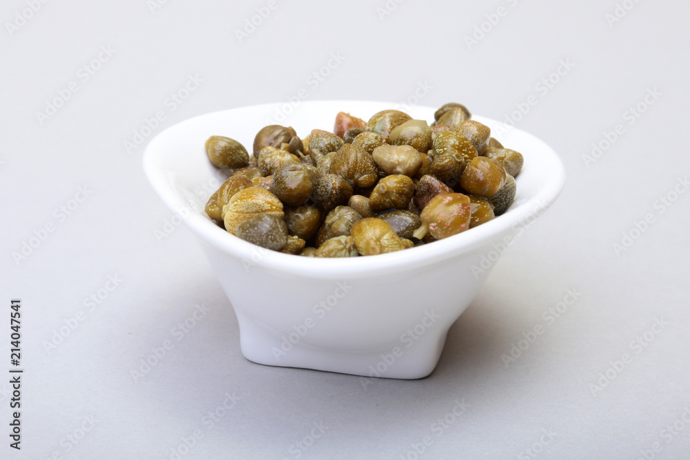 bowl with fresh capers isolated on white background. bowl with fresh capers isolated on white background.