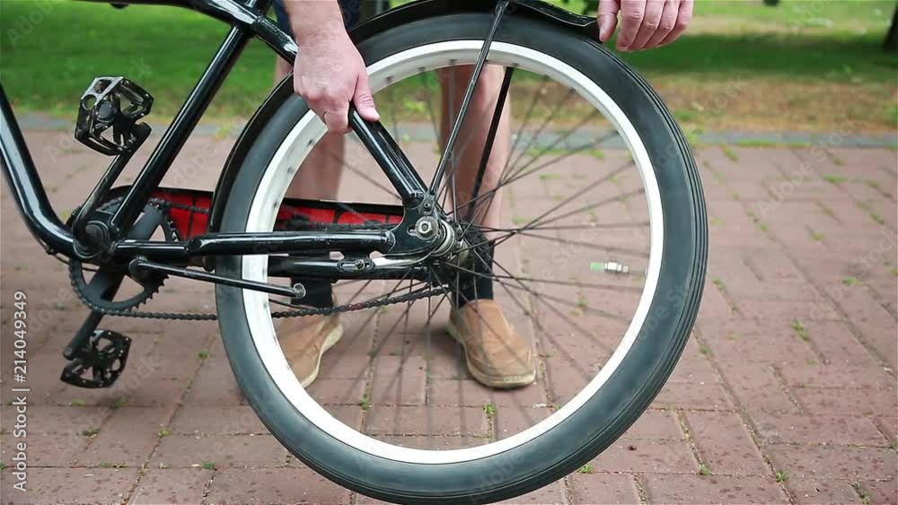 Man turns the wheel of a bicycle Man turns the wheel of a bicycle