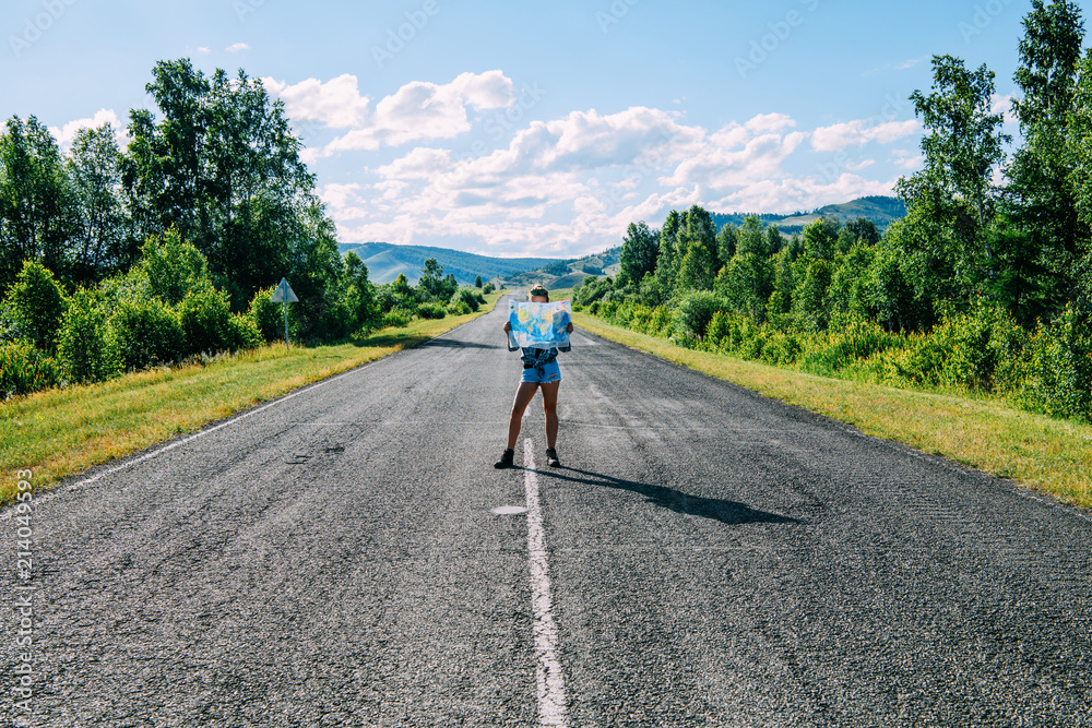 Obraz premium A girl with a map is staying on the road