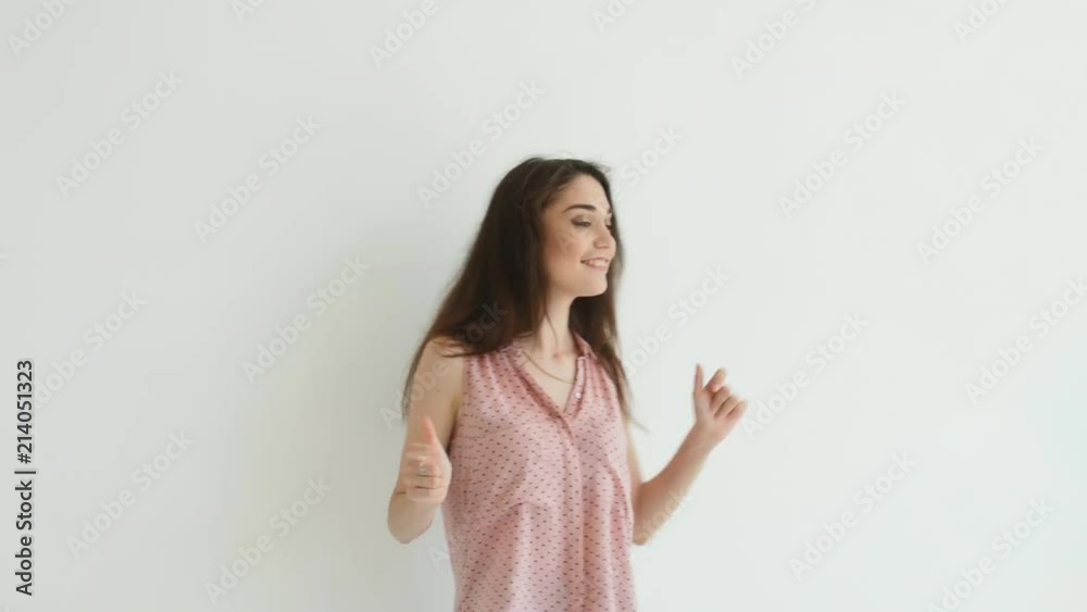 Young brunette woman dancing over white background Young brunette woman dancing over white background