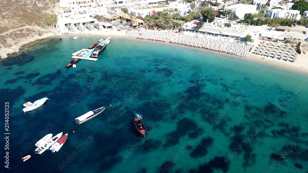 Aerial drone, bird's eye view photo of yachts docked in paradise beach of Psarou with popular pool luxury resorts, Mykonos island, Cyclades, Greece
