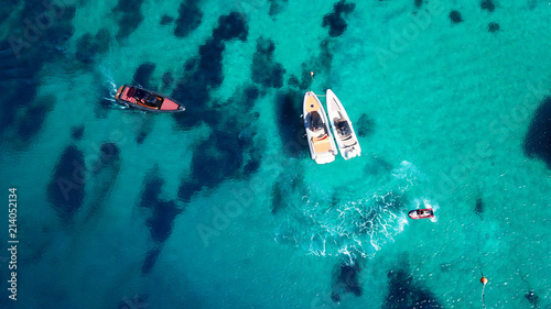 Aerial drone top view of docked inflatable speed boats in tropical emerald and sapphire sea
