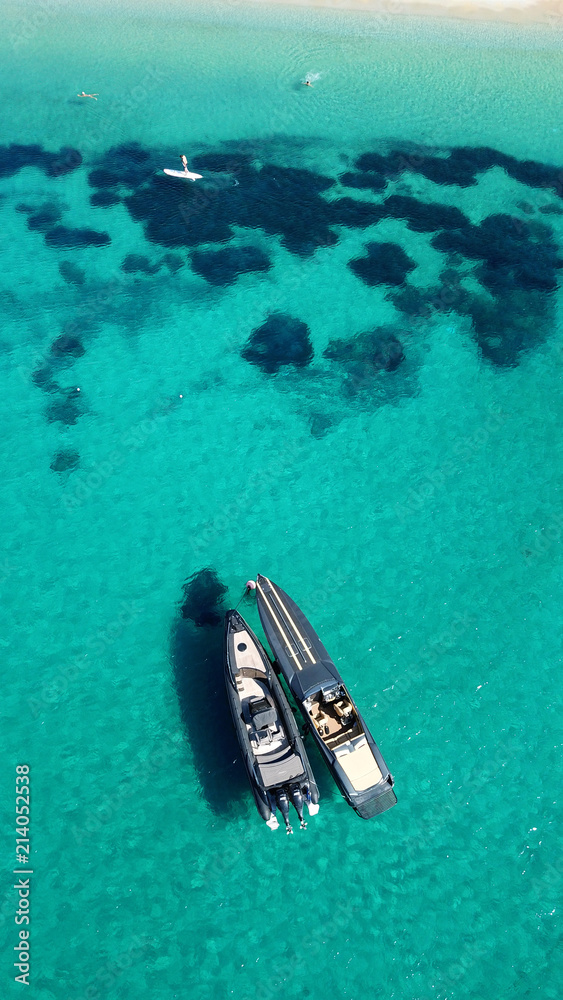 Aerial drone top view of docked inflatable speed boats in tropical emerald and sapphire sea