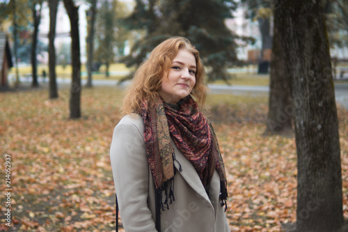 Cute young woman in coat walking in autumn Park
