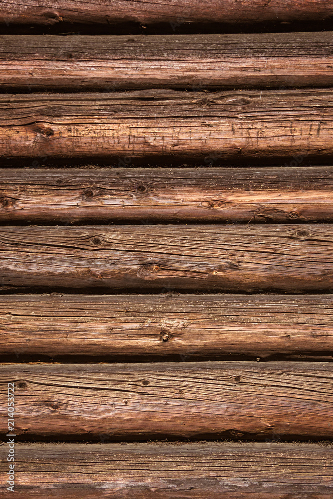 The wooden wall of a village house. Horizontal logs background The wooden wall of a village house. Horizontal logs background