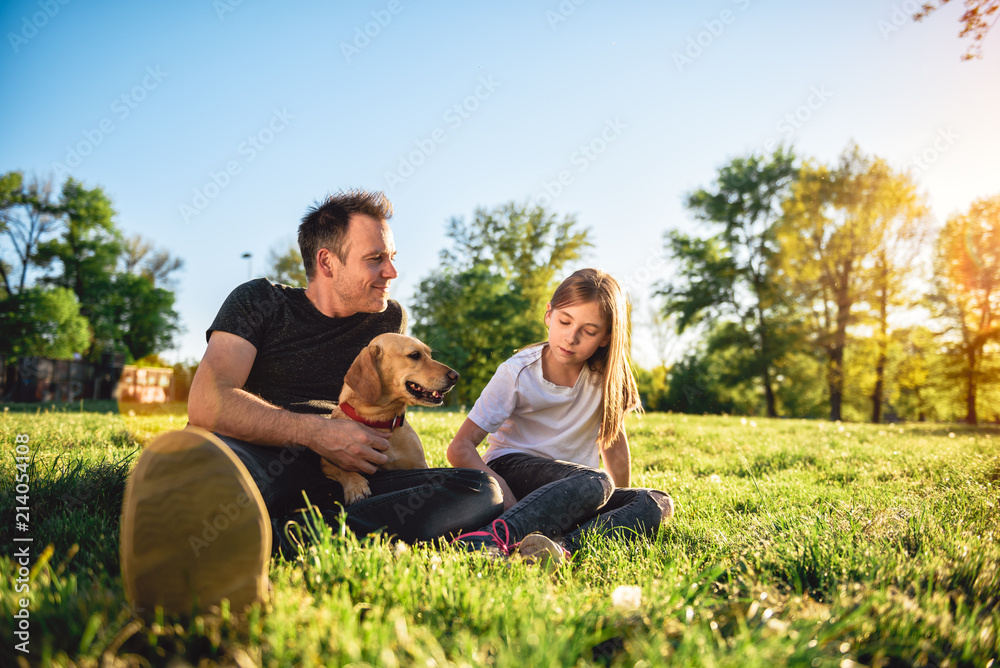 Father and daughter relaxing at park with dog Father and daughter relaxing at park with dog