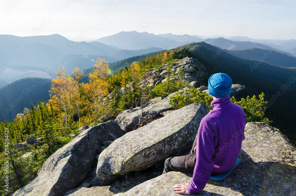 Tourist in the mountains contemplates the autumn beauty of nature