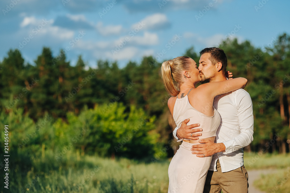 Happy couple spending time and hugging and about to kiss in beautiful sunset. Loving young man and woman on the nature Happy couple spending time and hugging and about to kiss in beautiful sunset. Loving young man and woman on the nature