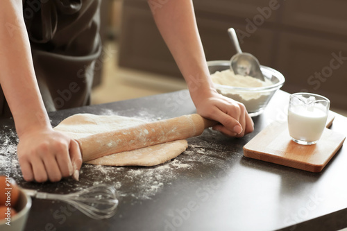Baker rolling dough on kitchen table