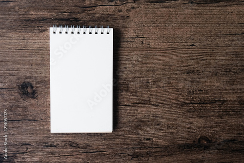 Top view image of open notebook with blank page on the wooden table..