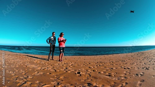 Filmer Girls Operating Quadcopter Drone On Sand Beach