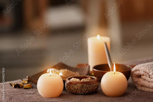 Burning candles on massage table in spa salon