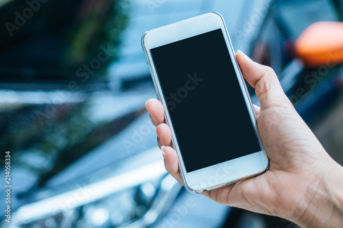 Woman hand holding smartphone with blank black screen.