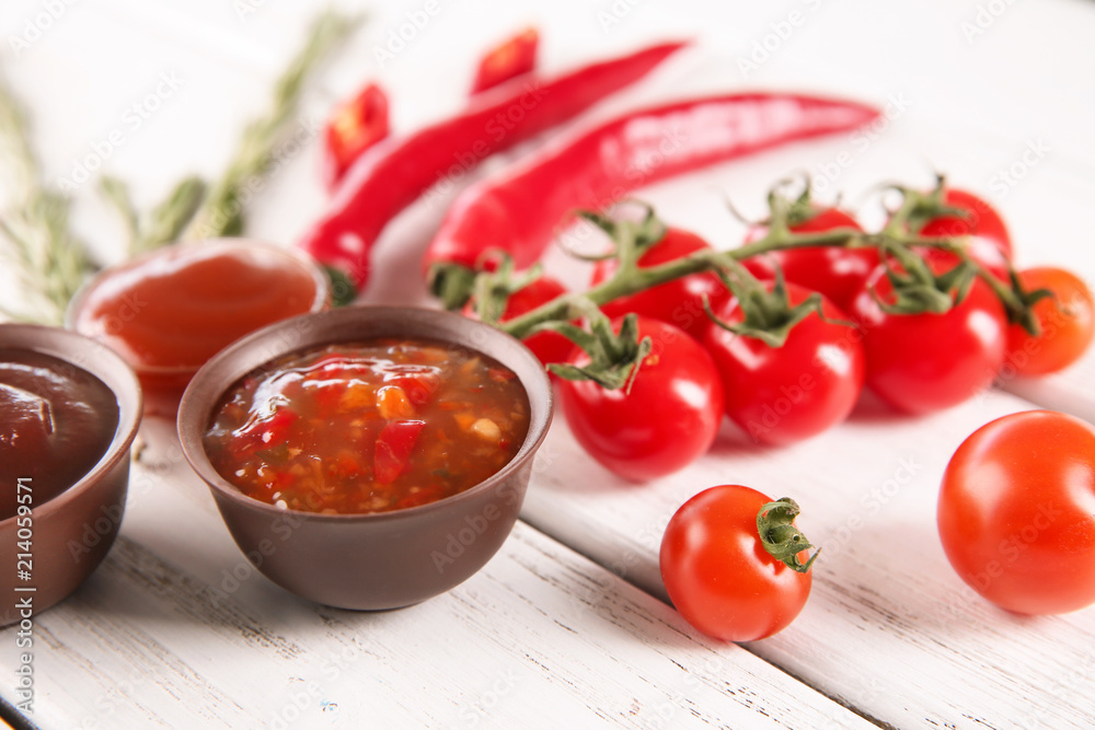 Bowls with different sauces and ingredients on table, closeup Bowls with different sauces and ingredients on table, closeup