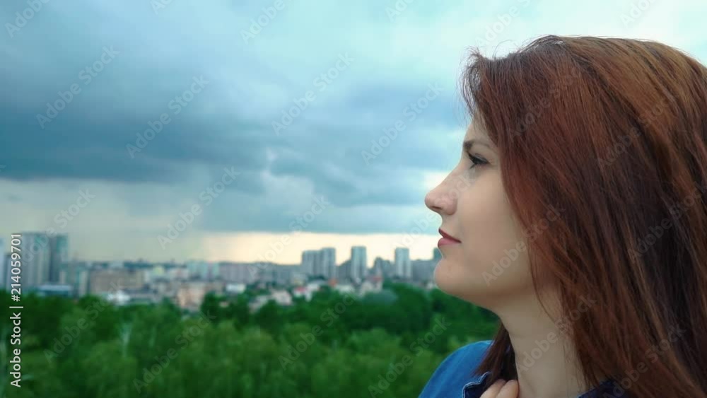 Profile of the girl against the sky, close-up. Red-haired woman looking at the sky Profile of the girl against the sky, close-up. Red-haired woman looking at the sky