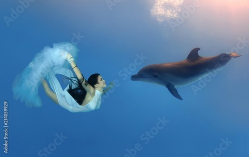 Woman swimming, diving with Bottlenose Dolphin (Tursiops truncatus)