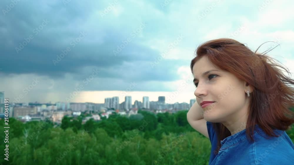 Girl straightens her hair looking into the distance. Profile of a girl on a nature background Girl straightens her hair looking into the distance. Profile of a girl on a nature background
