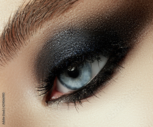 Close up view of young beautiful woman. Perfect skin and evening makeup. Silver smokey eyes. Macro studio shot. Sensuality, passion, cosmetology and modern makeup concept.
