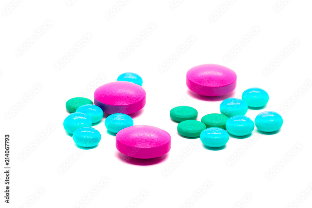 Rose tablets and colored pills scattered on the table. A concept with