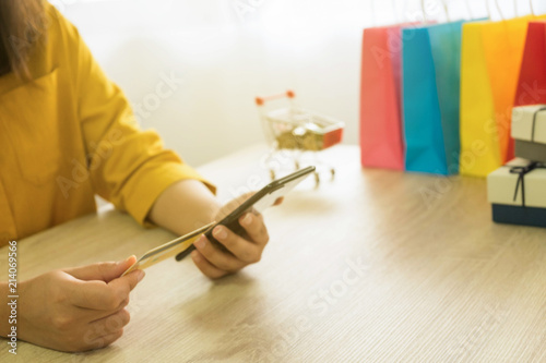 Woman holding credit card and using smartphone for shopping online.