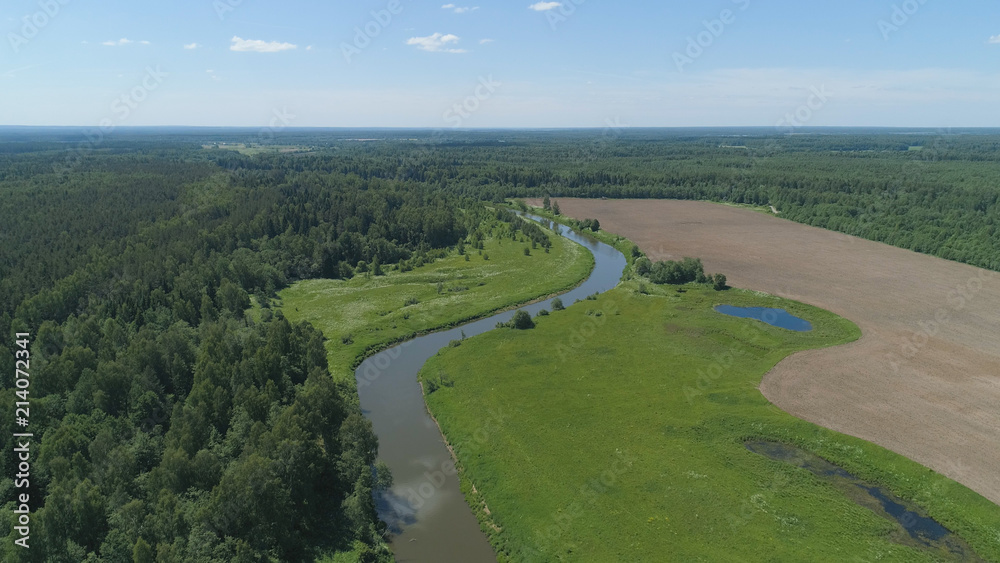 Aerial view summer landscape, river among trees, farmlands. Countryside with forest, the banks river covered with greenery.