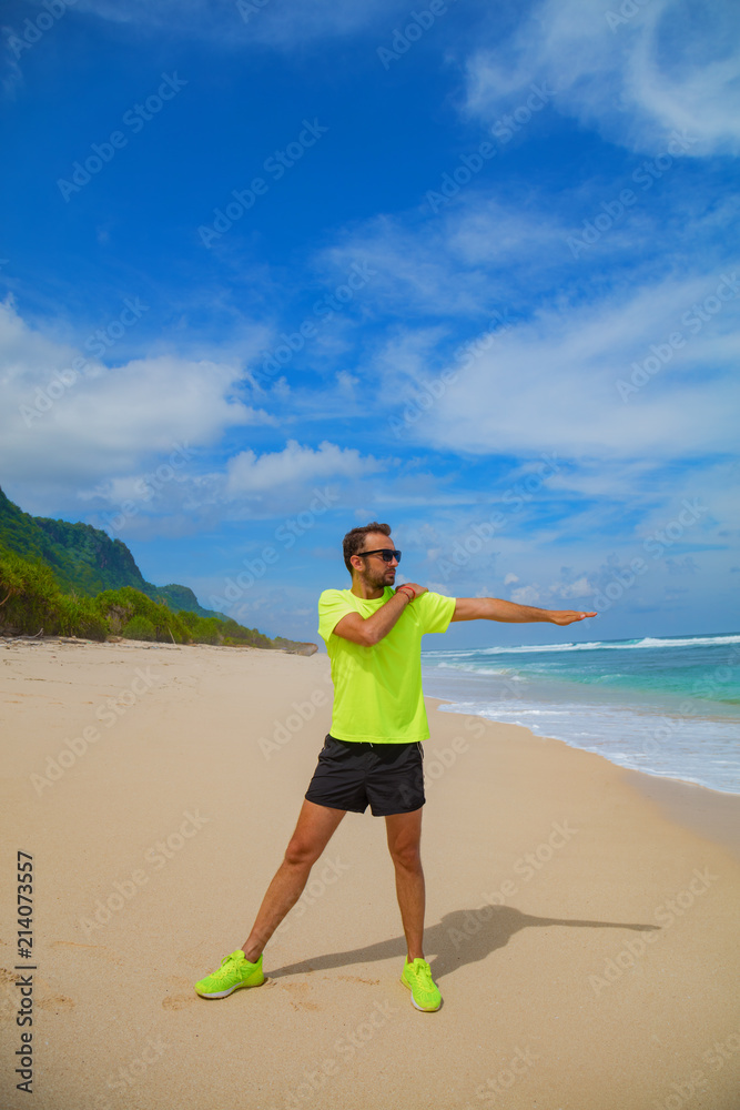 Sportsman stretching on the empty ocean beach. Sportsman stretching on the empty ocean beach.