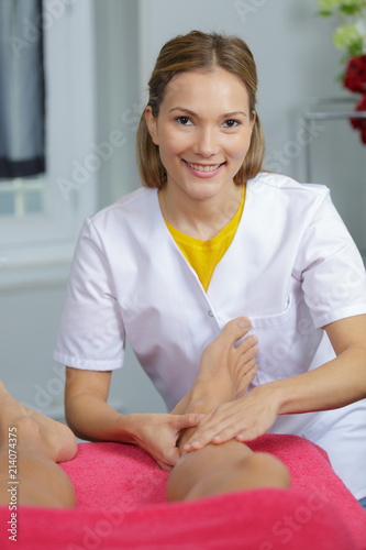 woman massaging the legs of man at spa center photo